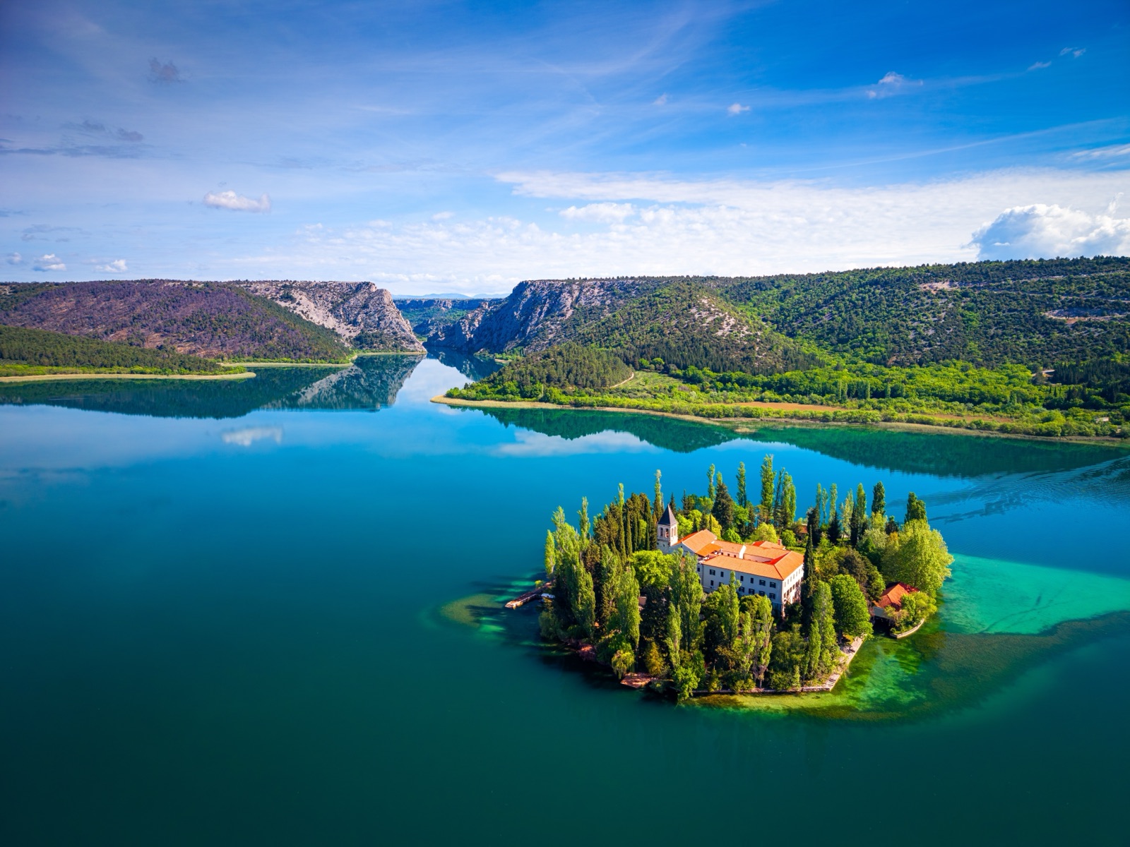 Die Insel Visovac mit ihrem Kloster mitten im See, dahinter der Krka-Canyon